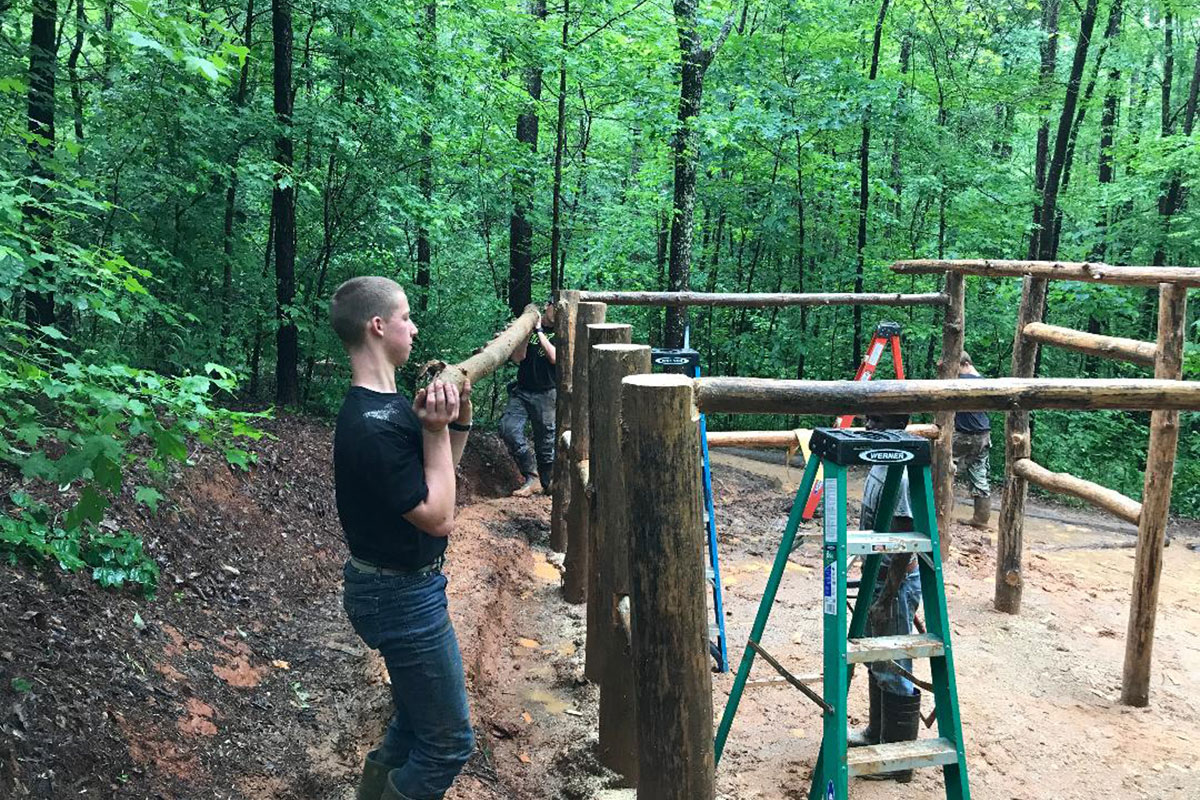 Samuel helping to build a tent at camp